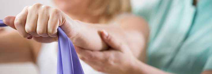 A person holding their arms out with a rehabilitation band.