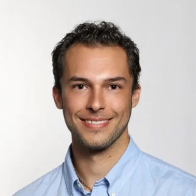 Austin Moya smiling in a blue button up.