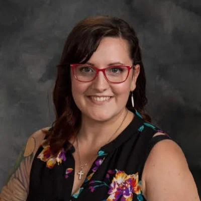 Lindsey smiling with red glasses on.