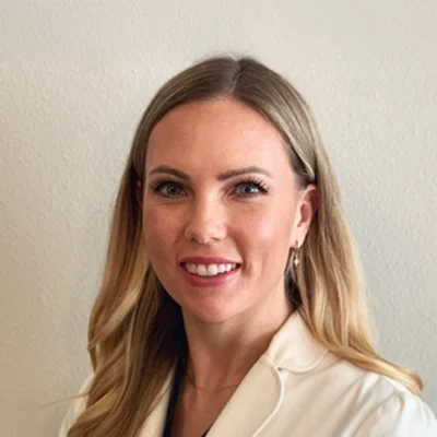 Dr. Alyssa Ognenovski smiling in a white shirt.